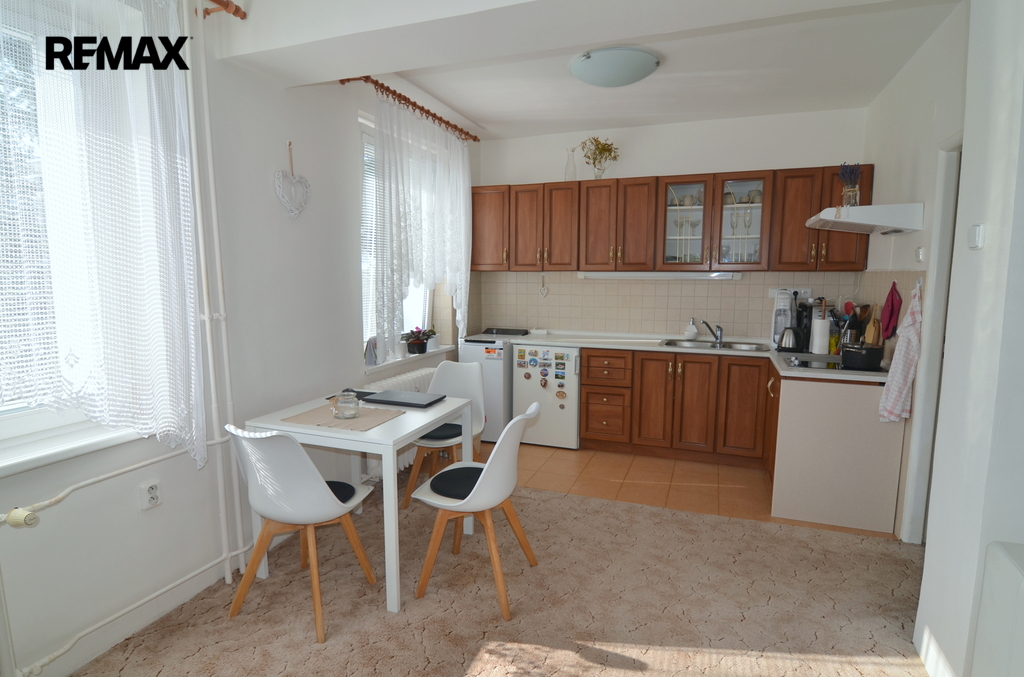 pohled na kuchyňský kout a jídelní stůl se třemi židlemi