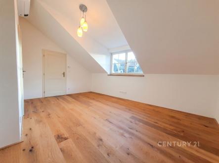 Podkrovní pokoj s dřevěnou podlahou a velkými okny, moderní interiér. | Pronájem bytu, 2+1, 83 m²