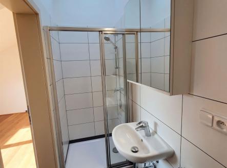 Malá koupelna s moderním sprchovým koutem, světlými dlaždicemi a velkým zrcadlem, poskytuje elegantní a funkční prostor v rekonstruovaném bytě | Pronájem bytu, 2+1, 83 m²
