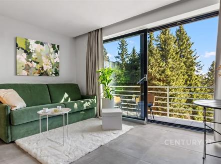 Světlý obývací pokoj s velkými okny, moderní dlažba a zelenou sedačkou, výhled na balkon. | Prodej bytu, 3+kk, 68 m²