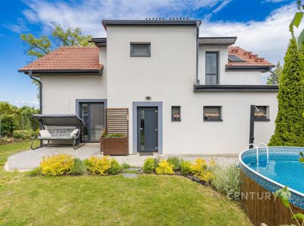 Moderní zahrada s terasou, nadzemním bazénem a dřevěnou houpačkou. Dominuje pečlivě udržovaný trávník a květinové záhony. | Prodej - dům/vila, 117 m²