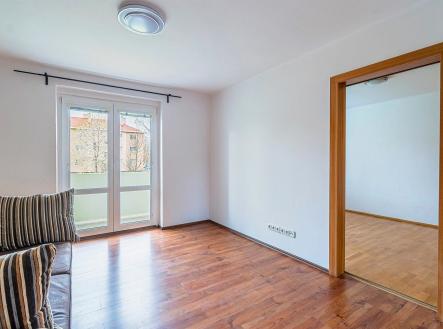 Světlý obývací pokoj s parketovou podlahou, velká okna zajišťují dostatek přirozeného světla, moderní styl interiéru. | Pronájem bytu, 2+1, 54 m²