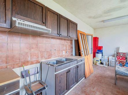 Kuchyň s dřevěnými skříňkami v rustikálním stylu, dlažba a vestavěný odsavač par, vyžaduje rekonstrukci. | Prodej - dům/vila, 240 m²