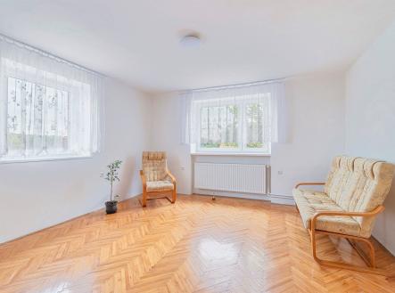 Světlý obývací pokoj s parketovou podlahou, velká okna s bílými závěsy, moderní výmalba a minimalistický nábytek pro pohodlné bydlení. | Pronájem bytu, 3+1, 80 m²