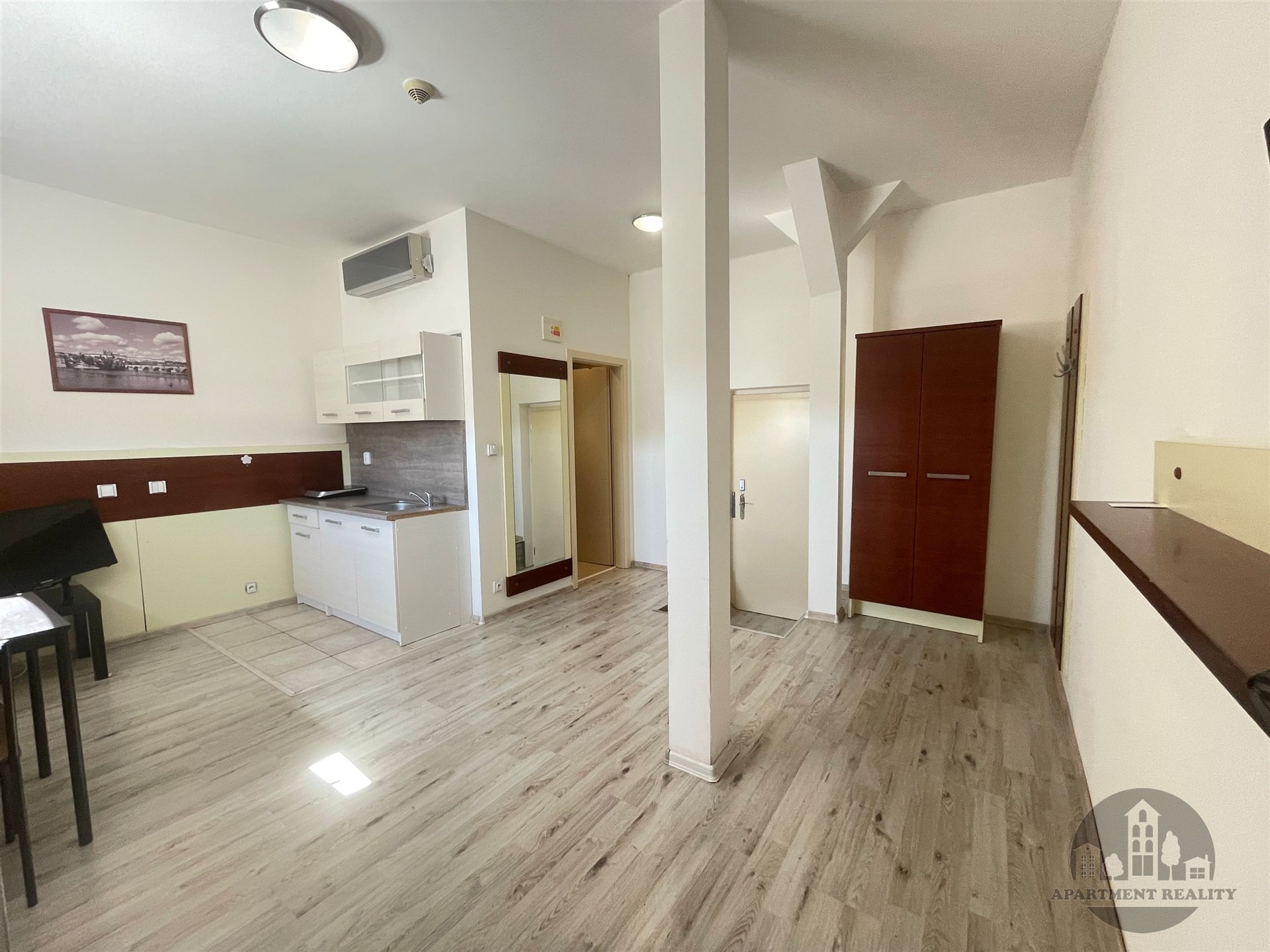 Světlý obývací pokoj s moderní parketovou podlahou, vestavěné skříně a klimatizace. Vhodné pro moderní městské bydlení.