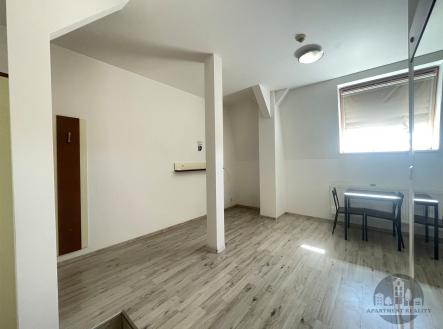 Světlá jídelna s moderní laminátovou podlahou, stůl pro dva, velké střešní okno, minimalistický design, dobré přírodní osvětlení. | Pronájem bytu, 1+kk, 24 m²