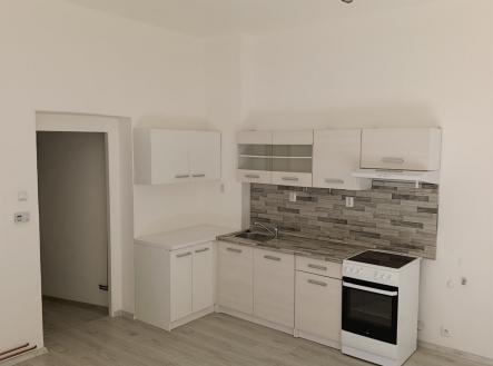 Moderní kuchyň s parketovou podlahou, světlými skříňkami a stylovým obkladem. Vhodná pro vytvoření příjemného kuchyňského prostoru. | Pronájem bytu, 2+kk, 51 m²