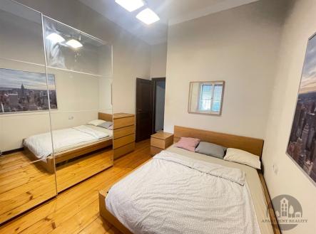 Prostorná ložnice s parketovou podlahou, vestavěné skříně a moderní světlé stěny poskytují elegantní a vzdušný pocit. | Pronájem bytu, garsoniéra, 13 m²