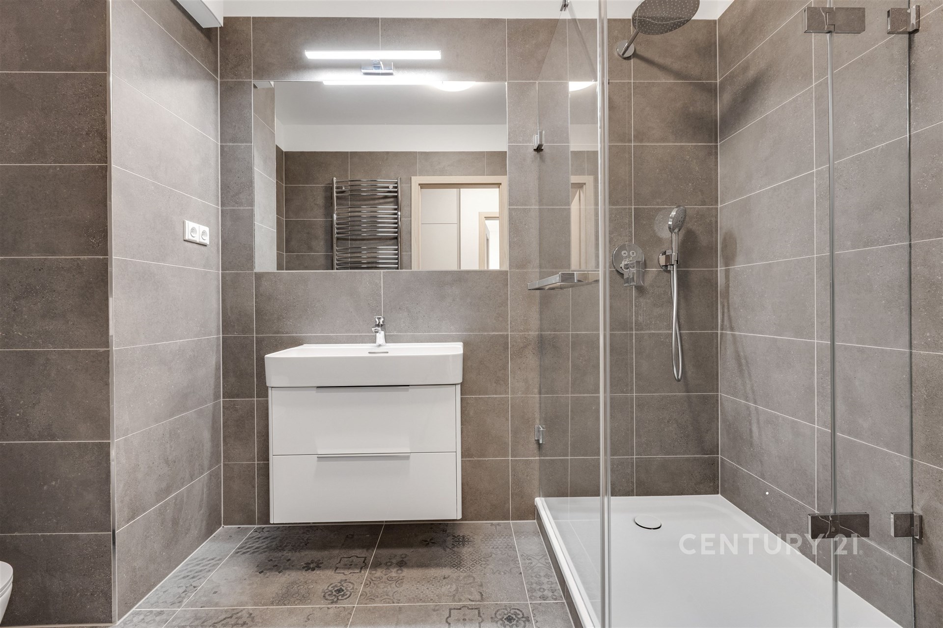 Koupelna se sprchovým koutem a závěsným wc.