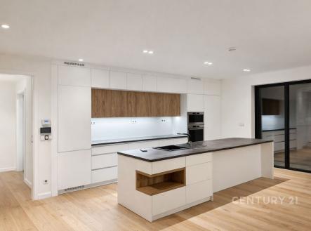 Moderní kuchyň s dřevěnou podlahou, vestavěnými spotřebiči a ostrovem. Světlý prostor s čistými liniemi a moderním designem. | Pronájem - dům/vila, 299 m²