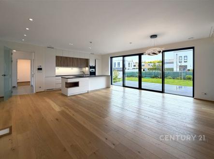 Prostorný obývací pokoj s moderní kuchyní, parketová podlaha, velká okna s výhledem do zahrady, světlý interiér. | Pronájem - dům/vila, 299 m²