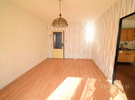 Světlý obývací pokoj s laminátovou podlahou, moderní tapetou a velkým oknem. Propojení s kuchyní pro praktické bydlení. | Prodej bytu, 3+1, 78 m²