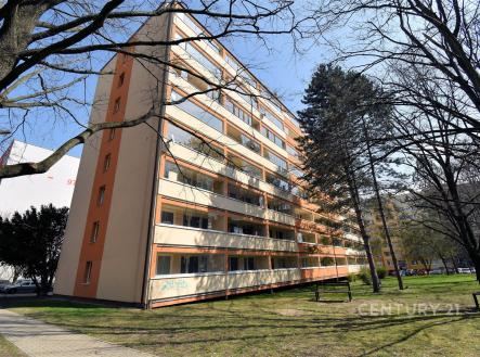 Panelový bytový dům se zateplenou fasádou a balkony, nacházející se v klidné části města, obklopený zelení a s parkovacími místy v okolí. | Prodej bytu, 3+1, 78 m²