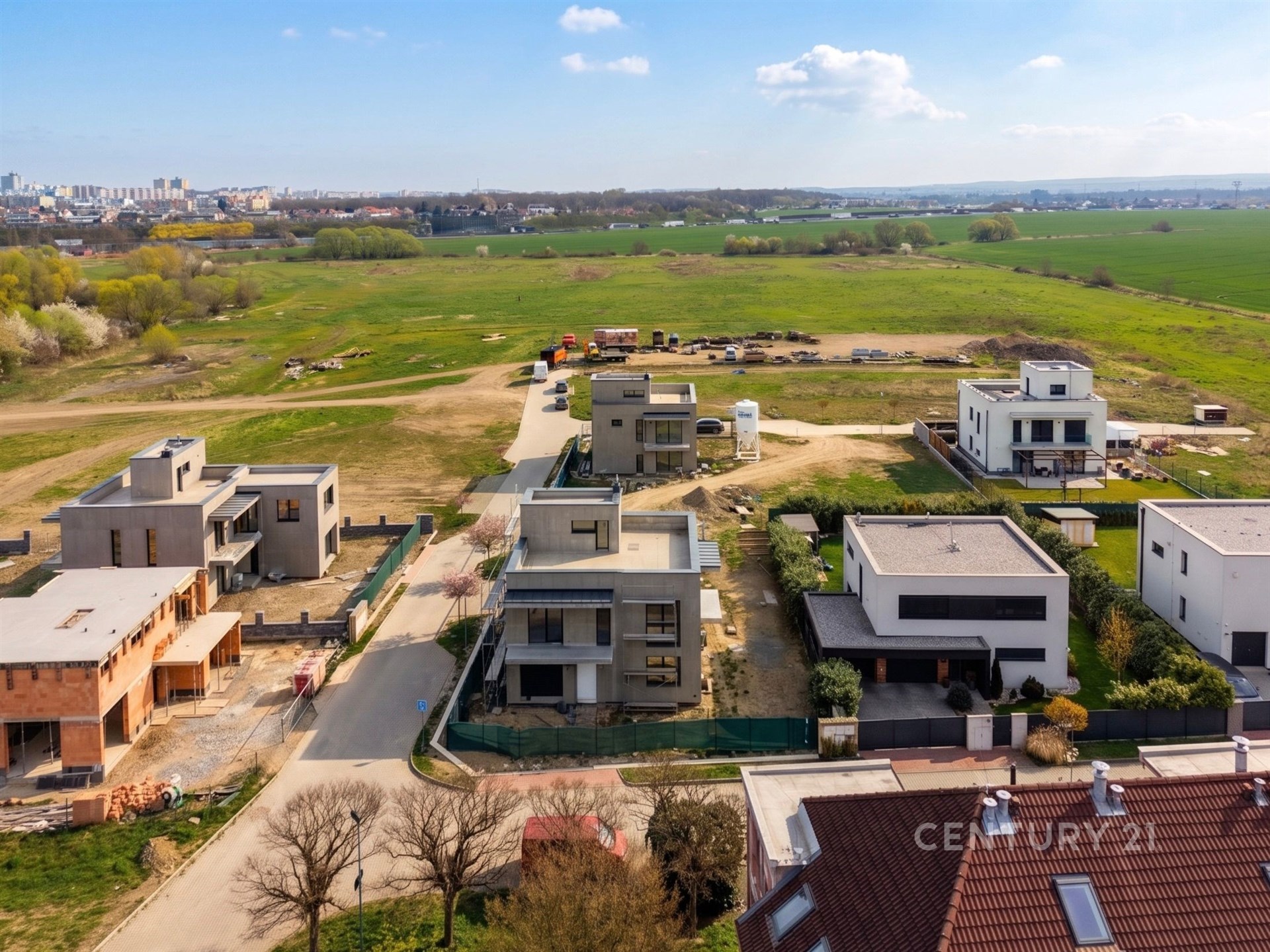 Moderní rezidenční čtvrť s novostavbami, rovná střecha, velká okna, klidné prostředí, výhled na krajinu