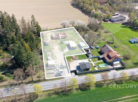 Letecký pohled na pozemek se stavebním pozemkem, obklopený zelení a přístupnou cestou, ideální pro výstavbu rodinného domu. | Prodej - pozemek pro bydlení, 3 208 m²