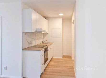 Moderní kuchyň s parketovou podlahou, bílými skříňkami a mramorovým obkladem, světlé a čisté provedení | Pronájem bytu, 2+kk, 47 m²