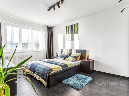 Prostorná ložnice s moderními dlažbami, velkými okny a elegantním nábytkem, poskytující světlý a vzdušný interiér. | Prodej bytu, 2+1, 57 m²