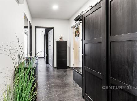 Chodba s moderní dlažbou, velkými černými vestavěnými skříněmi a světlými stěnami, které dodávají prostoru elegantní vzhled. | Prodej bytu, 2+1, 57 m²