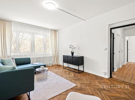 Světlý obývací pokoj s parketovou podlahou, velká okna, moderní vybavení, útulný interiér s elegantním nábytkem a výhledem do zahrady. | Prodej bytu, 2+1, 52 m²