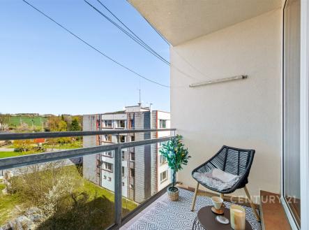 Balkón s moderní keramickou dlažbou, výhledem na okolní zeleň a pohodlným venkovním posezením, vhodný pro relaxaci. | Prodej bytu, 1+kk, 24 m²