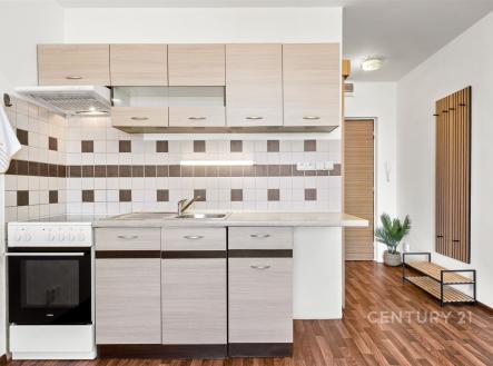 Moderní kuchyň s parketovou podlahou, světlými dřevěnými skříňkami a dlaždičkovým obkladem, světlý a účelný design | Prodej bytu, 1+kk, 24 m²