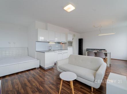 Moderní obývací pokoj s kuchyňským koutem, parketová podlaha, světlý interiér, velká okna, minimalistický styl. | Pronájem bytu, 1+kk, 43 m²