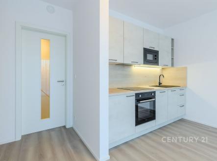 Moderní kuchyň s vestavěnými spotřebiči, světlá dvířka, parketová podlaha, minimalistický styl, ideální pro novostavbu. | Pronájem bytu, 1+kk, 43 m²