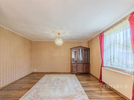 Tradiční obývací pokoj s parketovou podlahou, velkým oknem a elegantními závěsy, klasický styl a dřevěný nábytek dotvářejí útulnou atmosféru | Pronájem - dům/vila, 120 m²