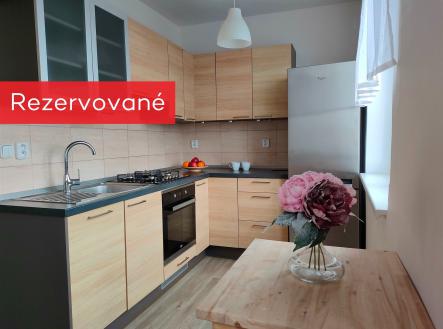 kuchyně s ploché panelové skříňky, trouba, závěsné osvětlení, dřevěná podlaha, a světle hnědé skříně | Pronájem bytu, 3+kk, 69 m²