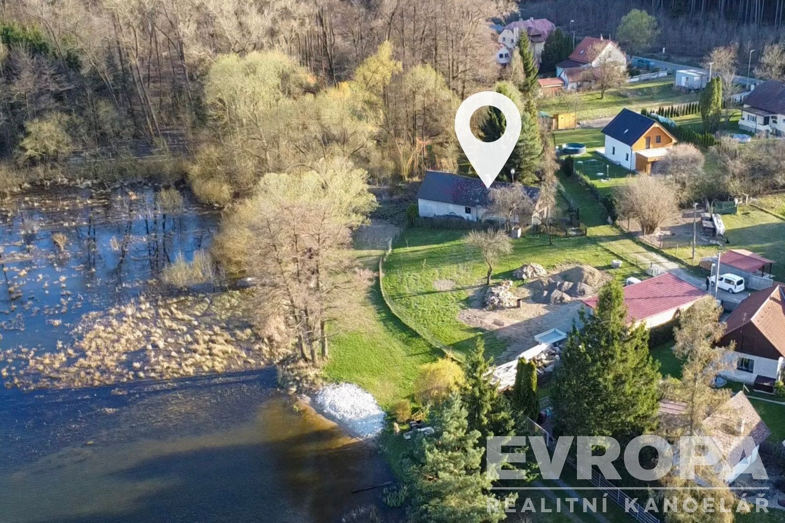 Letecký pohled na malebnou venkovskou nemovitost v blízkosti lesů a rybníka, s rozlehlým pozemkem a klidnou okolní přírodou.