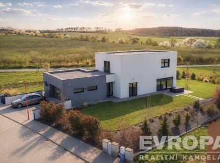 Moderní rodinný dům s plochou střechou, velká okna, zahrada a příjezdová cesta s dlažbou, nachází se v klidné přírodní lokalitě | Prodej - dům/vila, 229 m²