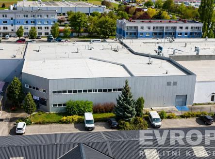 Průmyslová hala s moderní fasádou, rovnou střechou a parkovacími místy, ideální pro výrobu či skladování. | Pronájem - obchodní prostor, 600 m²