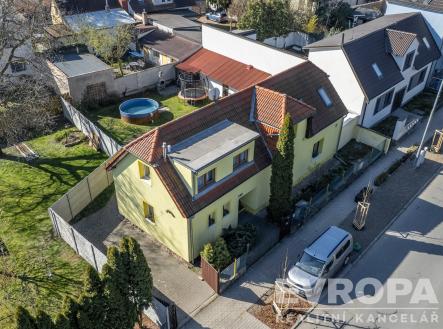 Rodinný dům s červenou střechou, umístěný v klidné rezidenční čtvrti, nabízí prostornou zahradu s bazénem a terasu. | Prodej - dům/vila, 213 m²