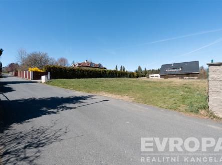 Prázdný pozemek na prodej s asfaltovou příjezdovou cestou, lemovaný živým plotem, ideální pro stavbu domu v klidné lokalitě. | Prodej - pozemek pro bydlení, 1 384 m²