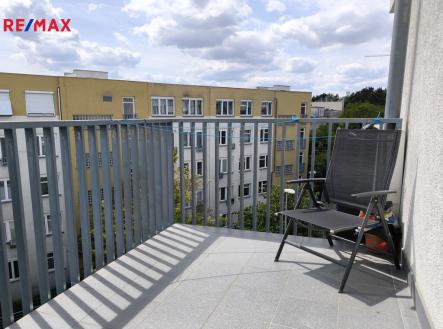 Obývací pokoj s kuchyňský koutem, jídelním koutem a vstupem na balkón. | Prodej bytu, 3+kk, 96 m²