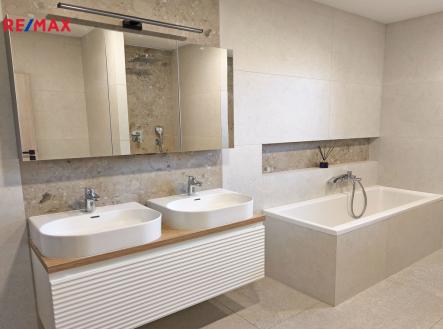 Koupelna s vanou, sprchovým koutem, toaletou a umyvadly s toaletní skříňkou. | Pronájem - dům/vila, 147 m²