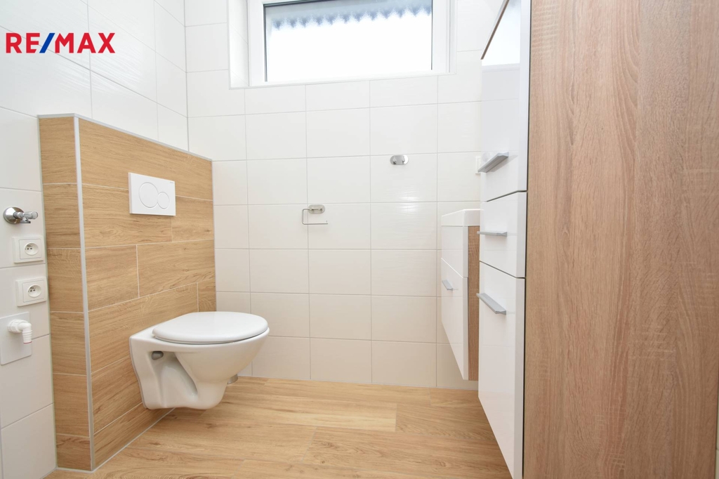 Koupelna se sprchovým koutem, toaletou, umyvadlem a místem na pračku.