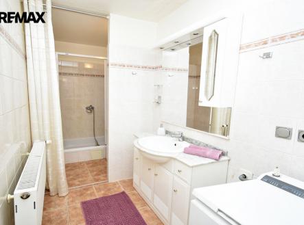 Koupelna se sprchovým koutem, místem na pračku a umyvadlo se skříňkou. | Pronájem bytu, 2+1, 92 m²