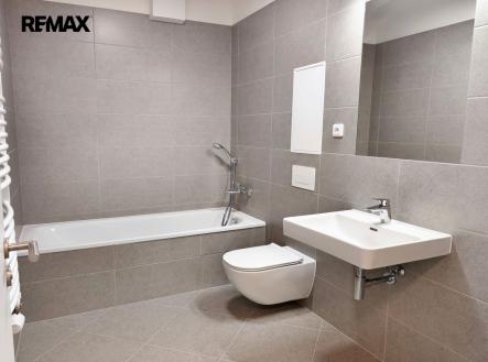 Koupelna s vanou, umyvadlem, toaletou a topným žebříkem. | Pronájem bytu, 2+kk, 50 m²