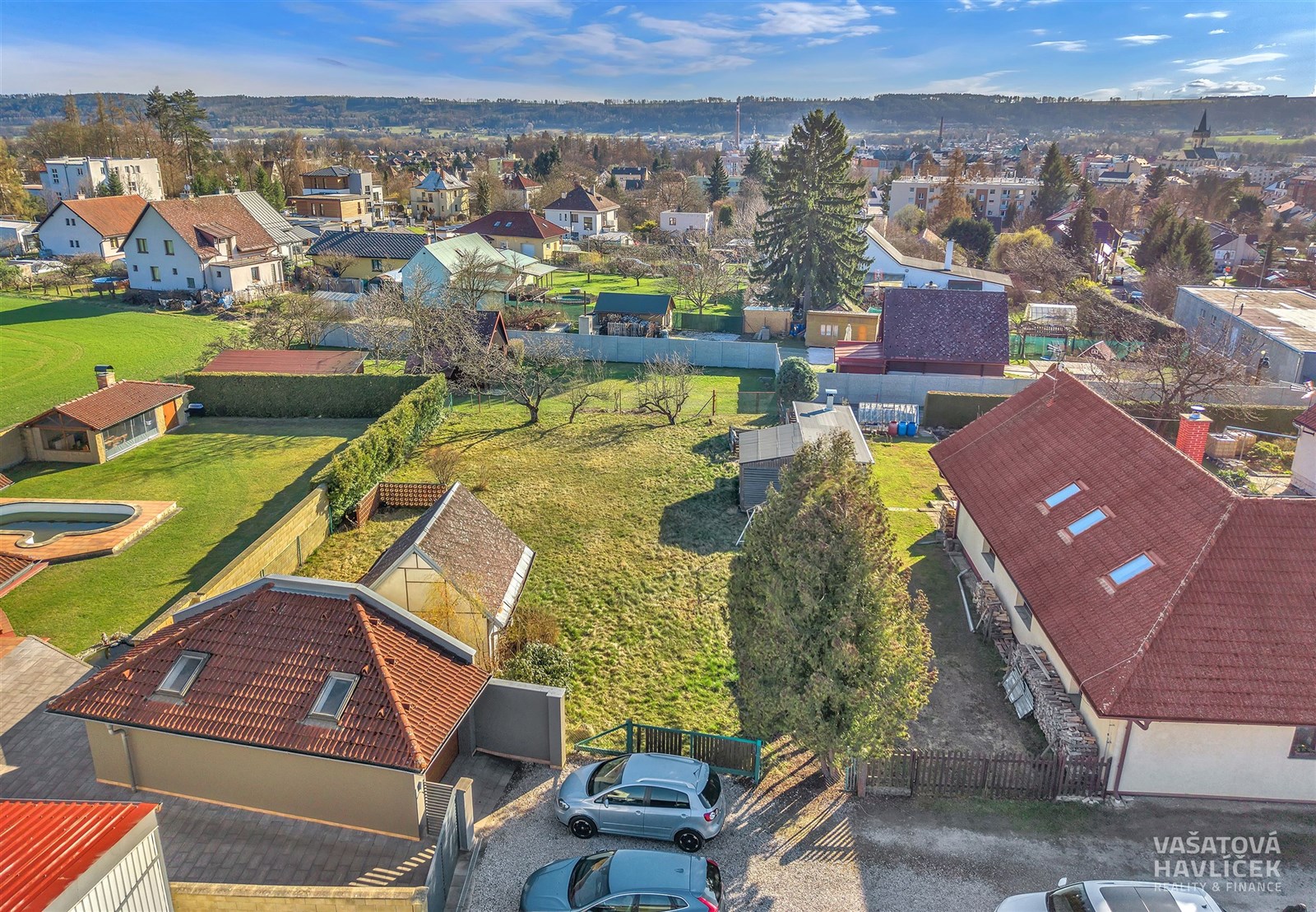 Prázdná slunná stavební parcela na prodej s výhledem na okolní rodinné domy a zahrady v klidné části města, ideální pro stavbu rodinného domu.