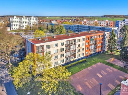 Venkovní pohled na bytový dům s moderní fasádou a novými okny, okolní upravená zeleň a blízké parkoviště poskytují příjemné bydlení. | Prodej bytu, 4+1, 78 m²