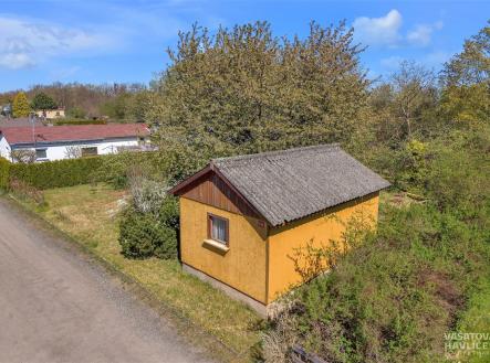 Malá zahradní chatka s žlutou fasádou a sedlovou střechou, obklopená zelení, ideální pro rekreační využití, nachází se v klidné lokalitě. | Prodej - chata/rekreační objekt, 23 m²