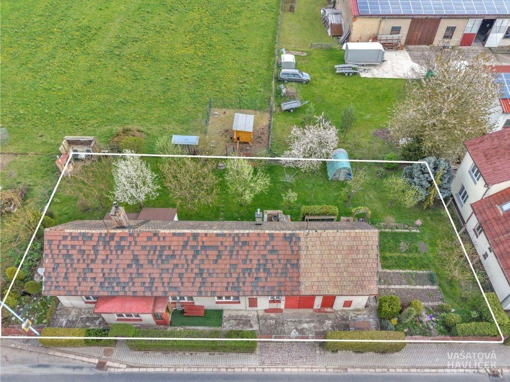 Přízemní dům s červenou střechou obsahuje prostornou zahradu s několika ovocnými stromy a zeleninovou zahrádkou, která se přirozeně hodí k posezení.