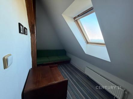 Podkrovní pokoj s moderním střešním oknem, kobercem a dřevěným nábytkem, vytápění radiátorem, vhodný pro efektivní využití prostoru. | Pronájem bytu, 4+1, 86 m²