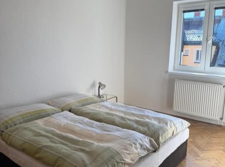 Světlá ložnice s parketovou podlahou, velkým oknem a minimalistickým stylem. | Pronájem bytu, 4+1, 86 m²