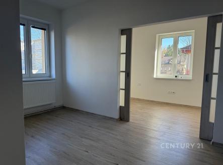 Světlá rekonstruovaná místnost s parketovou podlahou a velkými okny, které zajišťují dostatek denního světla. | Pronájem bytu, 3+1, 77 m²