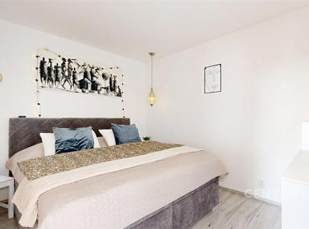Prostorná ložnice s moderní dekorací, laminátová podlaha, závěsné osvětlení, světlé stěny, elegantní atmosféra. | Prodej bytu, 3+1, 58 m²