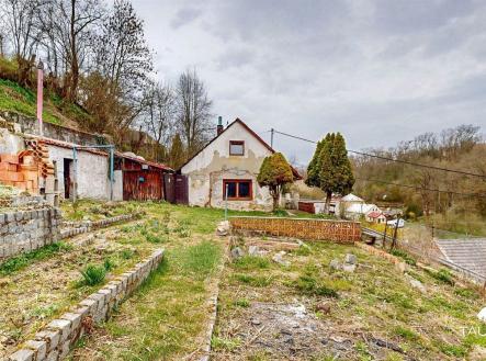 Šikmá zahrada u venkovského domu s cihlovou zídkou a dřevěnou kůlnou nabízí potenciál pro renovaci a úpravu krajiny. | Prodej - dům/vila, 94 m²