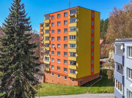 Barevná fasáda panelového domu s balkony obklopena zelení, zrekonstruovaná budova ve světlém stylu, klidná lokalita poblíž lesa. | Prodej bytu, 3+1, 58 m²