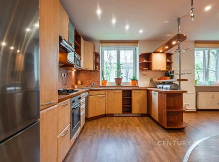 Moderní kuchyň s dřevěnými skříňkami, parketovou podlahou a velkými okny poskytujícími přirozené světlo | Prodej bytu, 3+kk, 66 m²